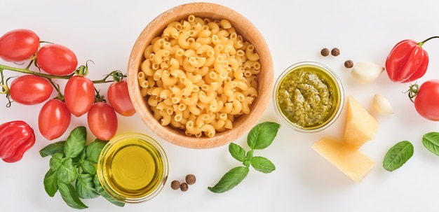 Espaguetis, tomate fresco, hierbas y especias. Composición de ingredientes alimentarios saludables aislados sobre fondo blanco, vista superior. Bosquejo.