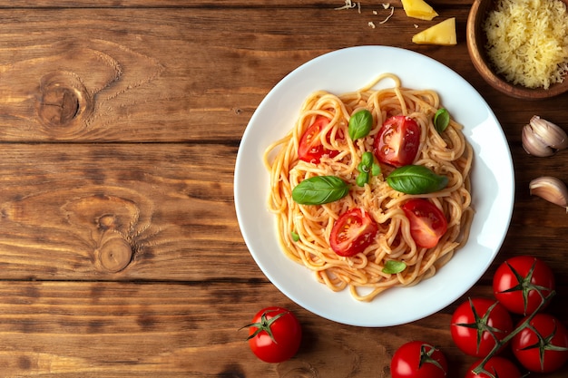 Espaguetis con tomate y queso en un espacio de madera