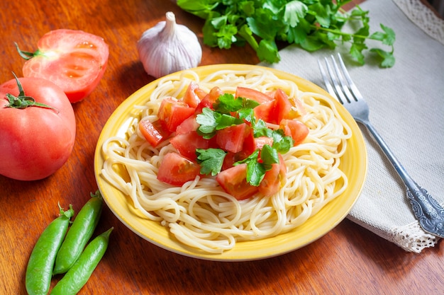 Espaguetis con tomates y hierbas en un plato