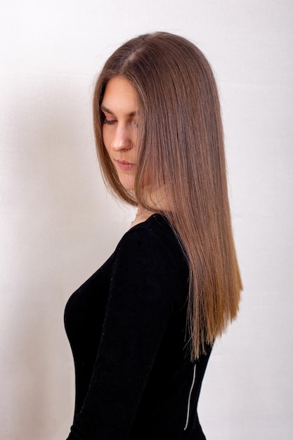 Espalda femenina con cabello largo y recto morena saludable en peluquería