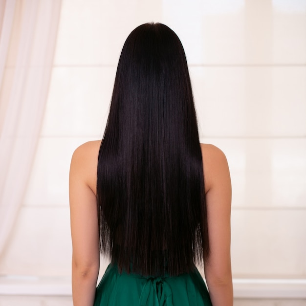 Espalda femenina con cabello largo y recto morena