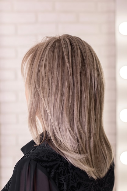 Espalda femenina con cabello rubio gris