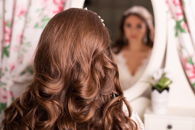 Espalda femenina con cabello rubio largo y rizado en peluquería con espacio para copiar