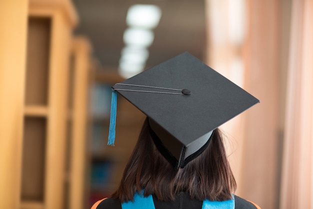 La espalda de los graduados, use la bata sombrero negro y borla azul