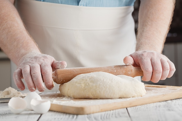 Espalhando a massa de biscoito com rolo de madeira