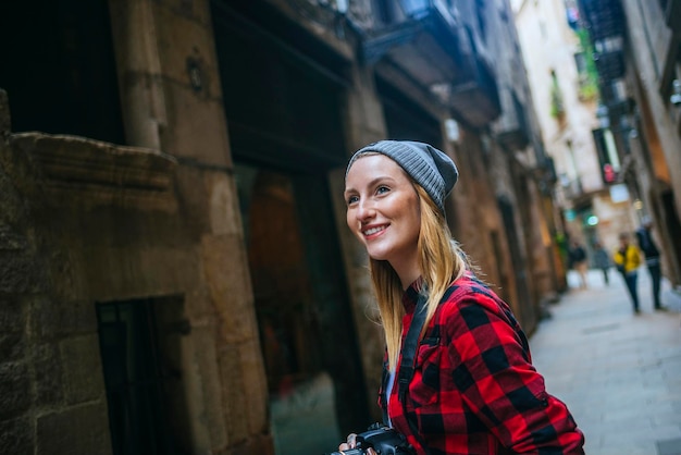 España, Barcelona, retrato de mujer sonriente con cámara en el Barrio Gótico