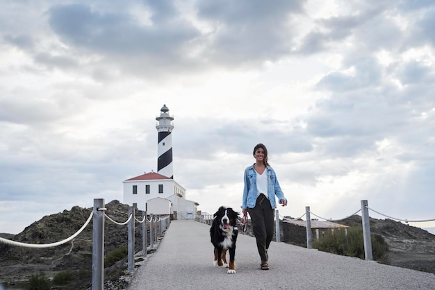 Espanha, Menorca, Bernese mountain dog caminhando junto com seu dono ao ar livre no farol