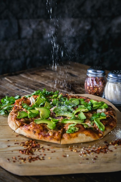 Se esparcen especias sobre la pizza.