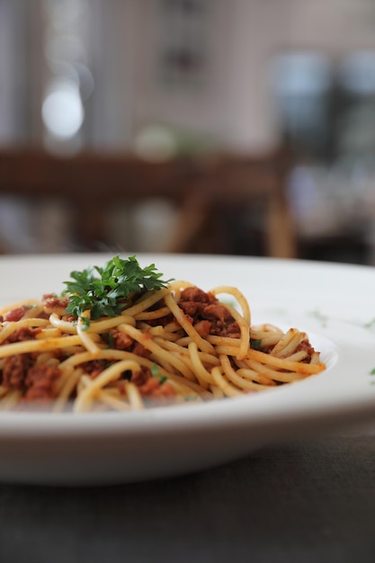 Esparguete à bolonhesa com molho de tometo de carne na mesa de madeira, comida italiana