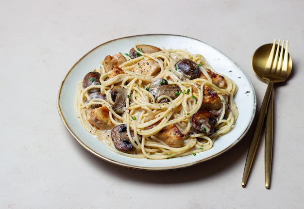 Esparguete de massa em molho cremoso com frango e cogumelos. comida italiana.