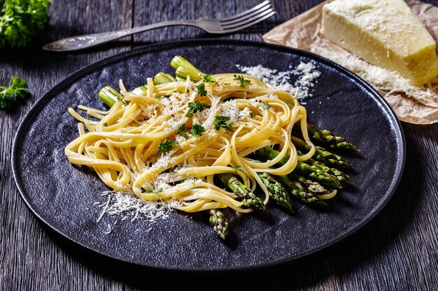 Foto espárragos asados con queso de pasta en placa