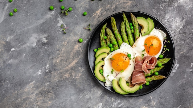 espárragos con prosciutto, aguacate y huevos fritos