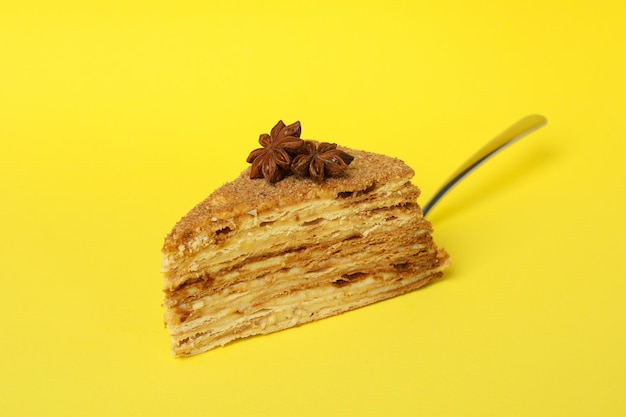 Espátula com pedaço de bolo de mel em fundo amarelo