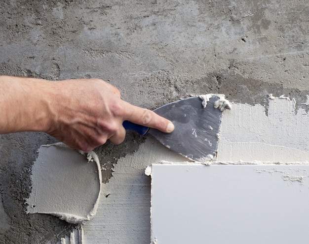 Espátula de construcción llana en azulejo trabajo con mortero