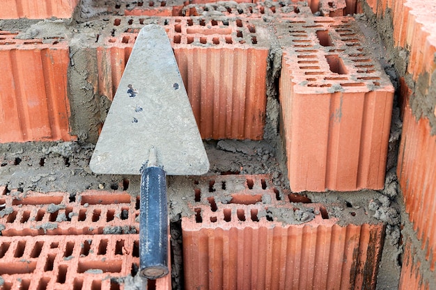 Espátula de construção para colocação de tijolos e blocos Ferramenta de construção de um pedreiro Ferramenta de trabalho manual no fundo da alvenaria