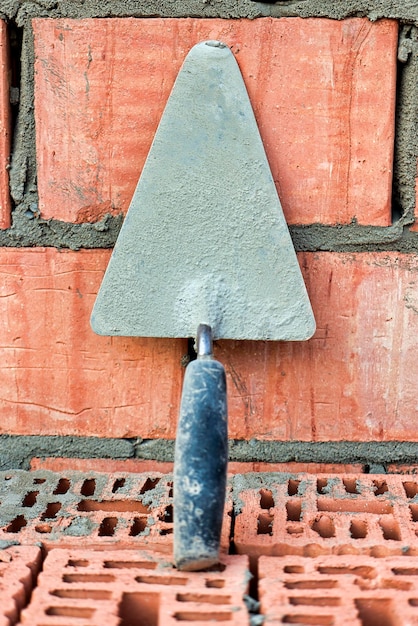 Espátula de construção para colocação de tijolos e blocos Ferramenta de construção de um pedreiro Ferramenta de trabalho manual no fundo da alvenaria