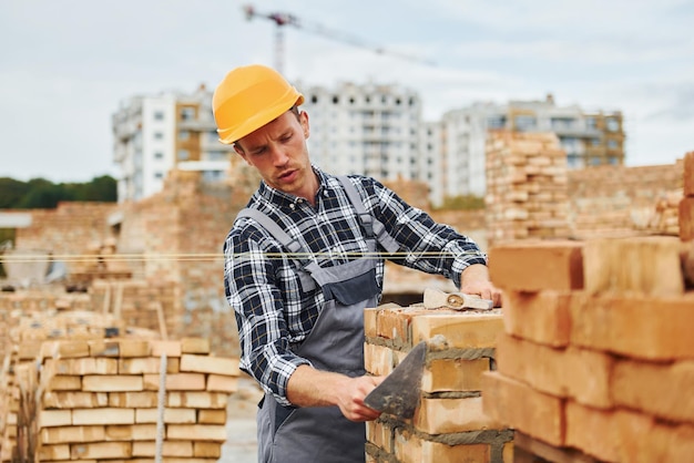 Con espátula para trabajadores de la construcción en uniforme y equipo de seguridad tienen trabajo en la construcción