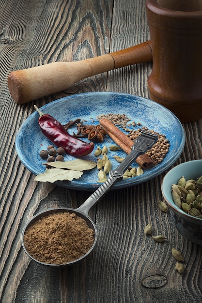 Foto especiais coloridos na mesa. pó indiano garam masala e seus ingredientes especiarias coloridas.