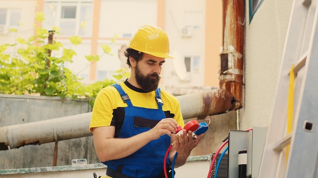 Especialista capaz contratado pelo cliente para detectar problemas no sistema de HVAC, rastrear a perda de pressão de azoto e ajustar os valores dos níveis de superaquecimento e subrefrigeração medidos por medidores de colector