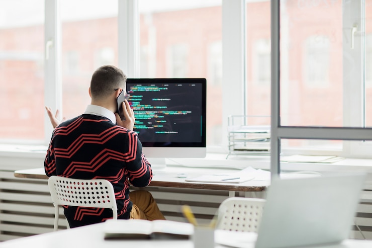 Foto especialista en codificación hablando por teléfono