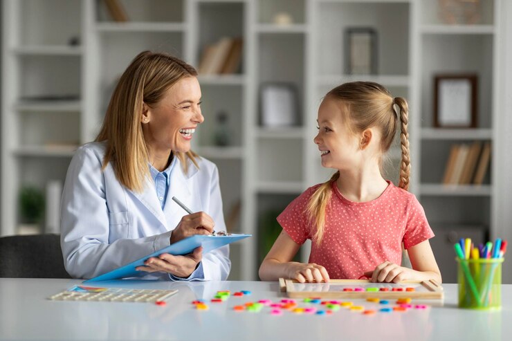 Especialista en desarrollo infantil feliz haciendo ejercicio con una niña y tomando notas