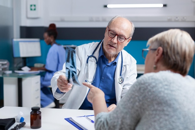 Especialista e paciente analisando resultados de radiografia para encontrar diagnóstico e tratamento, olhando para o exame de raio-x. Clínico geral explicando a doença dos ossos e falando sobre medicina