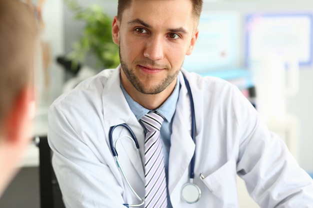 Especialista em clínica sorridente falando com o paciente