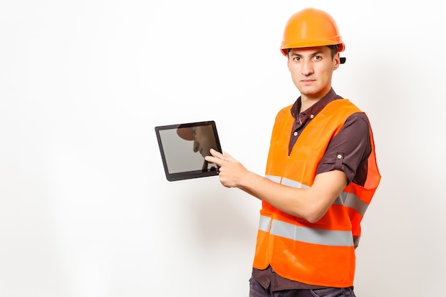 Especialista em construção usando um computador tablet. Em um canteiro de obras.