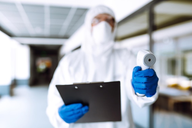 Foto especialista em controle de doenças com um equipamento para verificar a temperatura no escritório