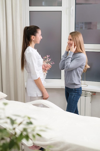 Especialista em medicina estética falando com cliente na clínica