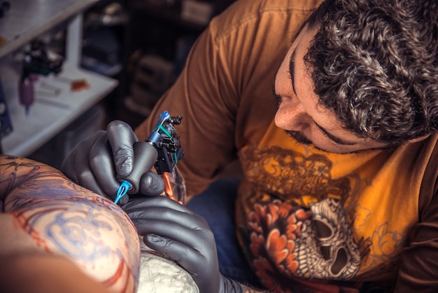 Especialista em tatuagem cria tatuagem em estúdio de tatuagem