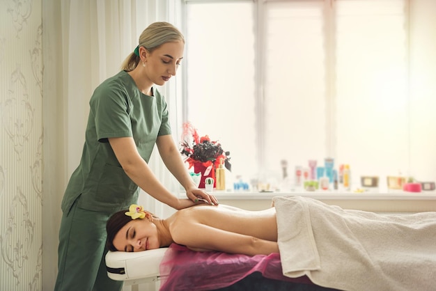 Especialista em terapeuta feminina faz massagem anticelulite no cliente de volta no salão spa