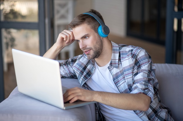 Especialista em TI. Um homem concentrado resolve uma tarefa complicada enquanto trabalha