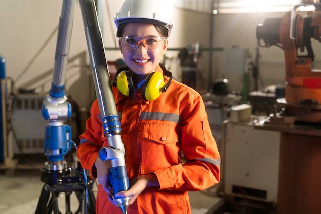 Especialista engenheira asiática com máquina de medição com braço manipulador medição de coordenadas tridimensionais verifique os tamanhos verificação 3d dos tamanhos das peças cmm após o processo de usinagem