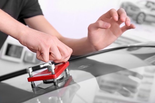 Especialista en la fijación de grietas en el parabrisas del coche en el taller de reparación