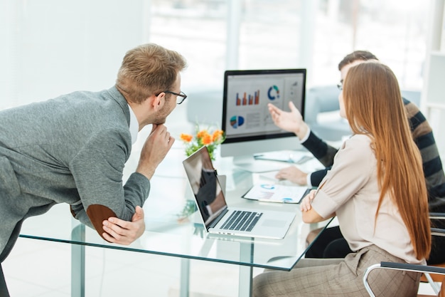 Foto especialista en finanzas y equipo profesional de negocios realizando análisis de informes de marketing, en una oficina moderna.