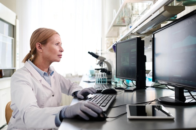 Especialista de laboratorio femenina que trabaja en la computadora