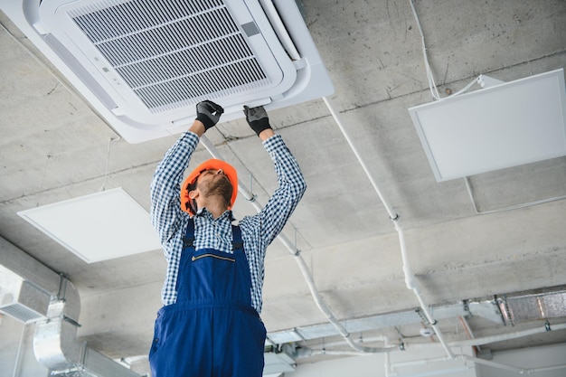 Foto especialista limpia y repara el aire acondicionado de pared