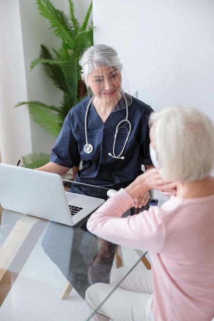 Especialista médico visitando a un paciente anciano en su casa