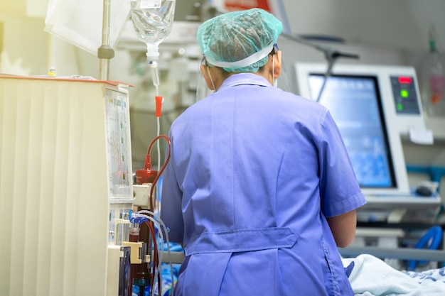 Foto el especialista está revisando el equipo de terapia de reemplazo renal continuo y la bomba de inyección y la máquina de hemodiálisis.