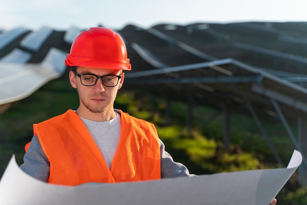 Especialista solar en uniforme con un plan eficiente de baterías en la granja en el exterior