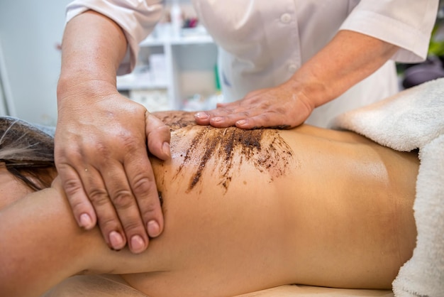 especialista terapeuta faz uma massagem terapêutica nas costas de uma cliente feminina em um salão de spa conceito de saúde e beleza corpo saudável postura saudável