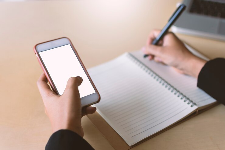 Foto los especialistas en marketing en línea levantan la pantalla de los dispositivos móviles pantalla blanca con fondo dorado bokeh