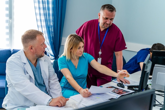 Especialistas médicos discutiendo el diagnóstico médico en la pantalla de la computadora Especialistas encontrando formas de tratamiento de problemas de salud