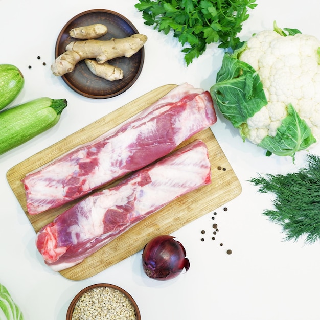 Foto especiarias de cereais de vegetais verdes frescos de carne crua em um fundo branco