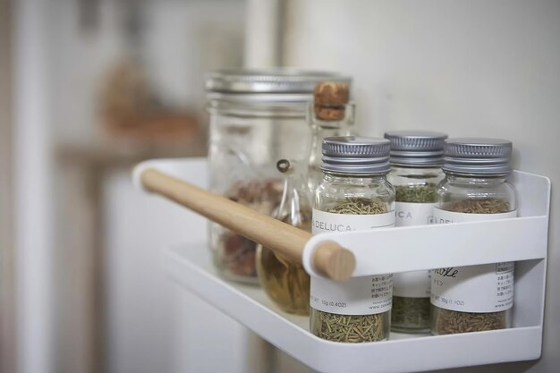 Foto especiarias diferentes em potes na prateleira no interior da cozinha fecham