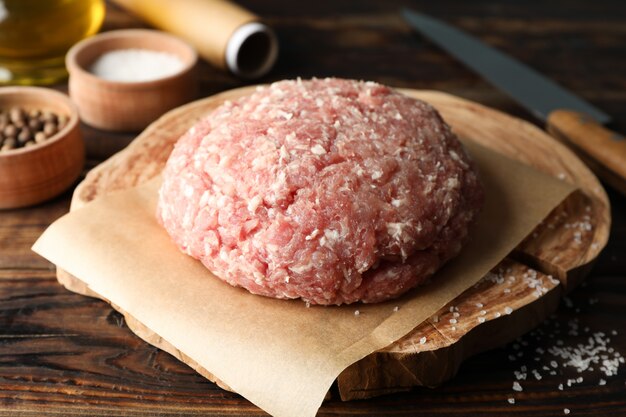 Foto especiarias e tábua com carne picada e faca em madeira, close-up