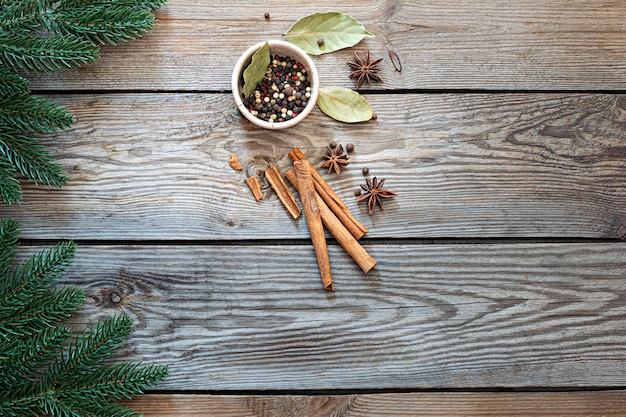 Especias navideñas tradicionales para cocinar y beber (vino caliente) sobre un fondo de madera