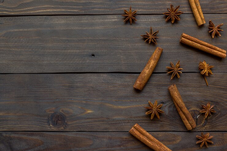 Especias picantes palitos de canela y anís estrellado sobre fondo de madera oscuro