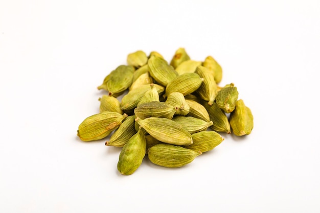 Especias de semillas de cardamomo verde seco fresco sobre superficie blanca,